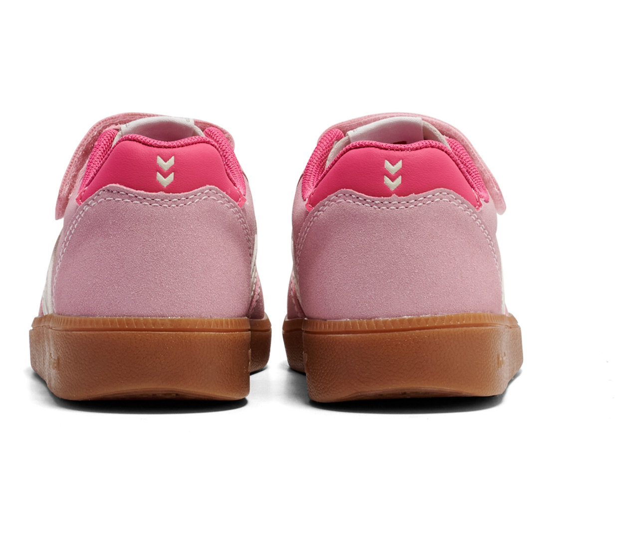 Vue arrière de deux baskets roses hummel® Handball Perfekt CL JR avec fermeture velcro et semelle marron.