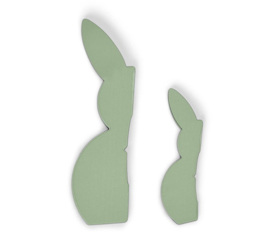 Deux décorations en forme de lapin vert clair sont posées sur un fond blanc.