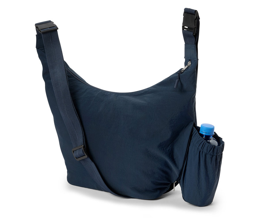 Gros plan d'un sac à bandoulière bleu marine avec une bouteille d'eau dans la poche latérale.