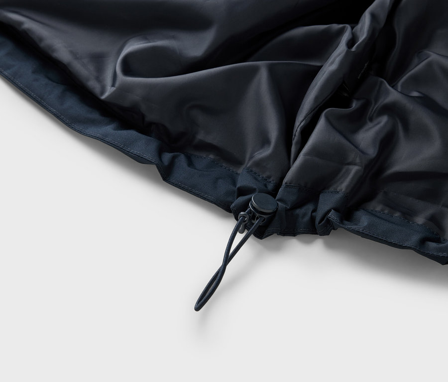 Vue détaillée de l'intérieur d'une veste bleu foncé avec cordon de serrage.