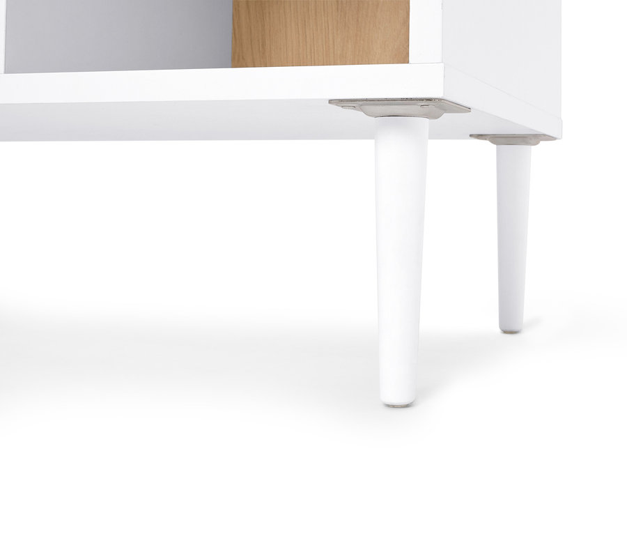 Gros plan sur deux pieds de meuble blancs sous une étagère blanche.