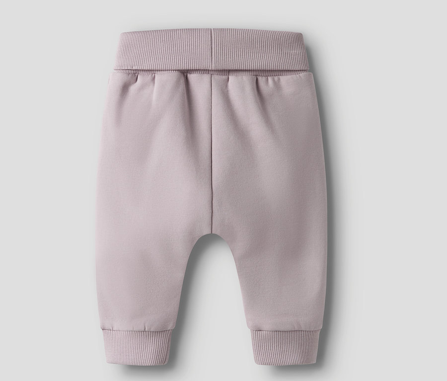 Gros plan sur un pantalon de bébé lilas avec des bordures côtelées à la taille et aux chevilles.