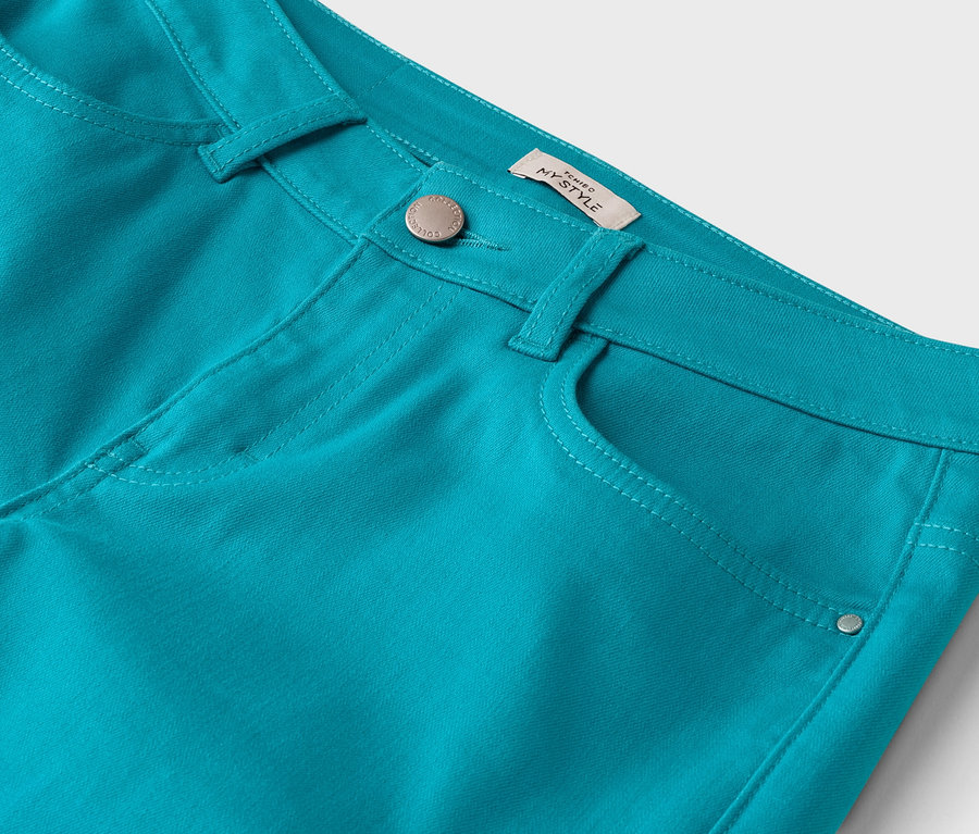 Gros plan d'un pantalon turquoise avec des poches et une étiquette "NY Style".