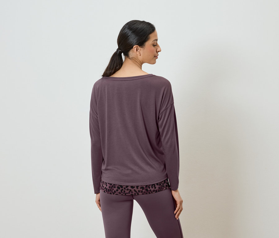 Femme vue de dos portant un haut aubergine à manches longues et un pantalon assorti.