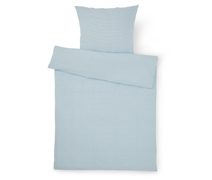 Vue de dessus d'une parure de lit à rayures bleu clair et blanches avec un oreiller et une housse de couette sur fond blanc.