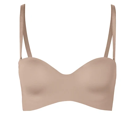 Un soutien-gorge couleur chair sans bretelles avec bretelles sur un fond blanc.