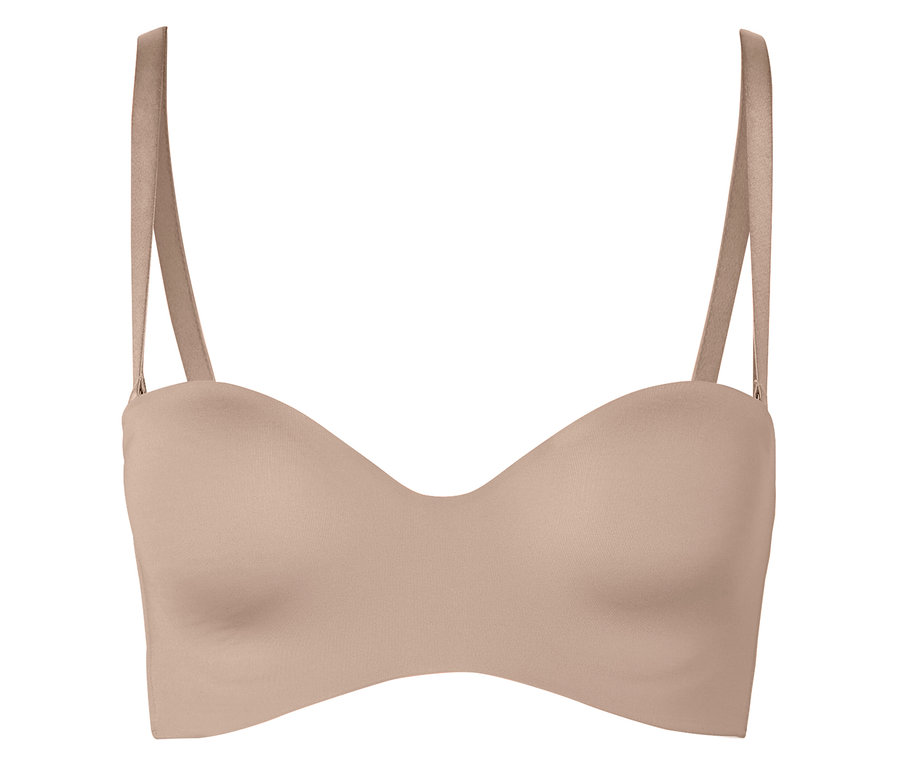 Un soutien-gorge couleur chair sans bretelles avec bretelles sur un fond blanc.