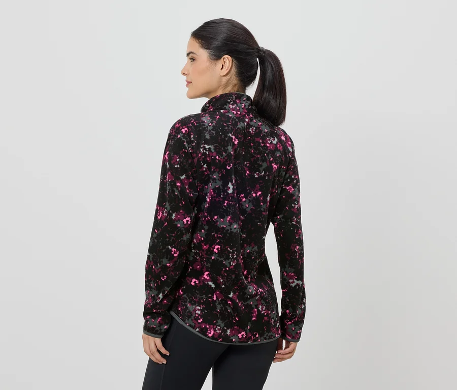 Femme vue de dos portant une veste polaire à motifs zippée et un legging noir.