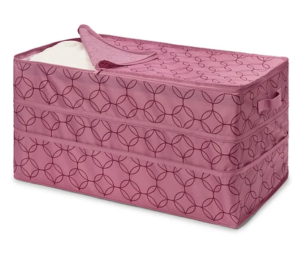 Boîte en tissu rose avec fermeture éclair et motif géométrique, partiellement remplie de tissu blanc.
