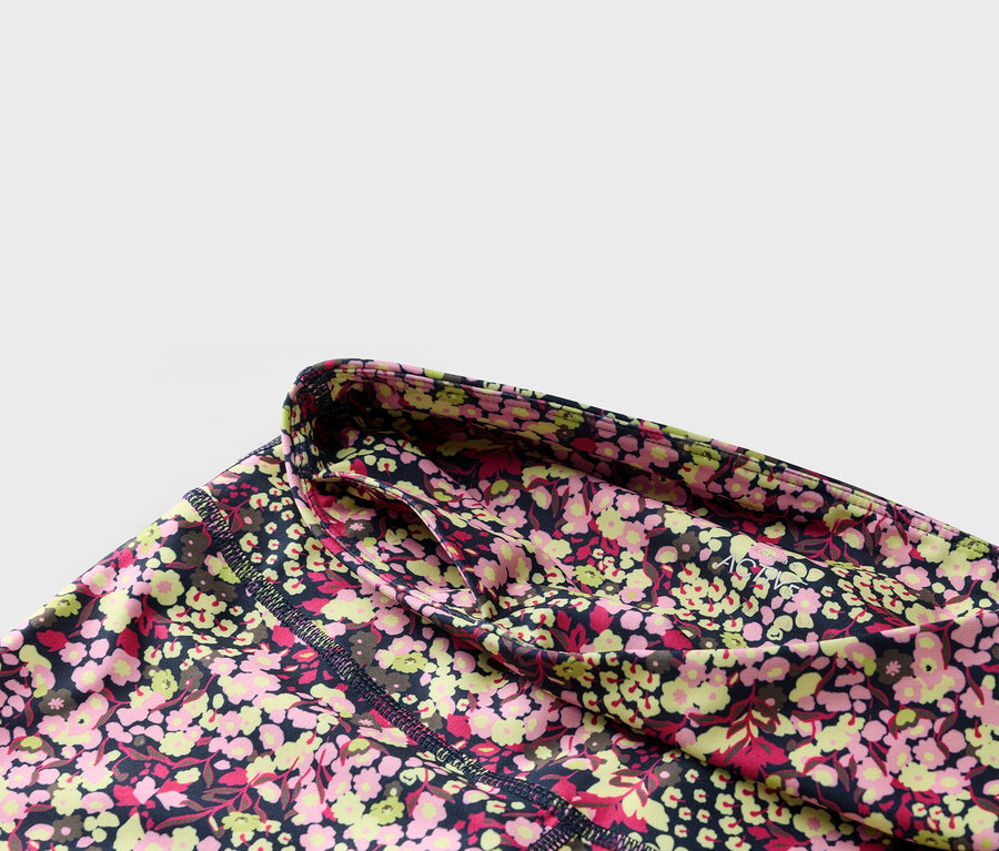Gros plan d'un legging à fleurs avec une ceinture bleu marine et une poche latérale.