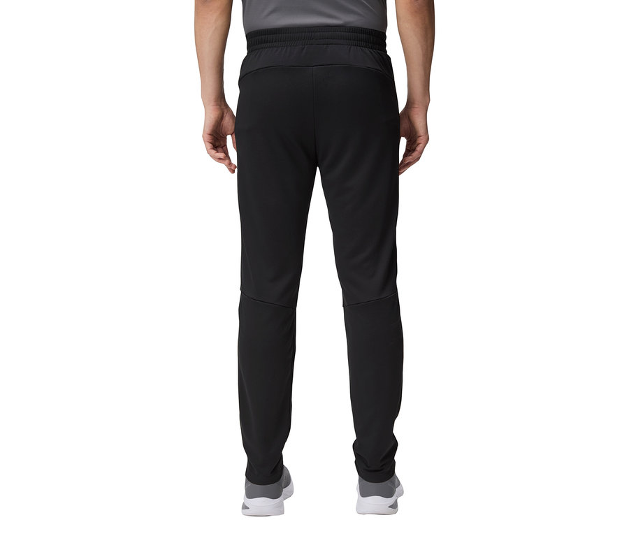 Gros plan sur l'arrière d'une personne portant un pantalon de survêtement noir et des chaussures grises.