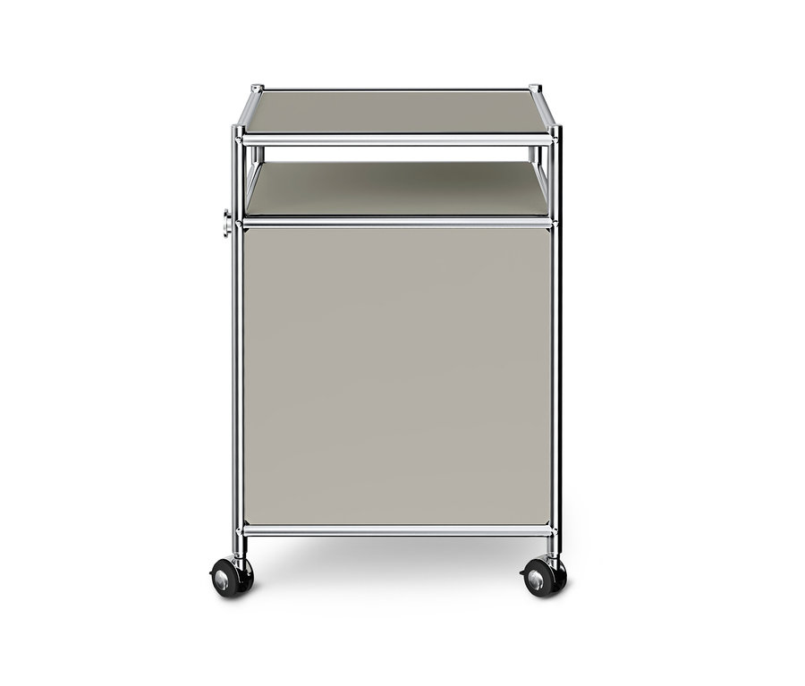 Meuble de rangement modulaire gris clair avec cadre chromé, comprenant une surface supérieure, une étagère ouverte, un compartiment fermé et quatre roulettes noires, sur fond blanc.