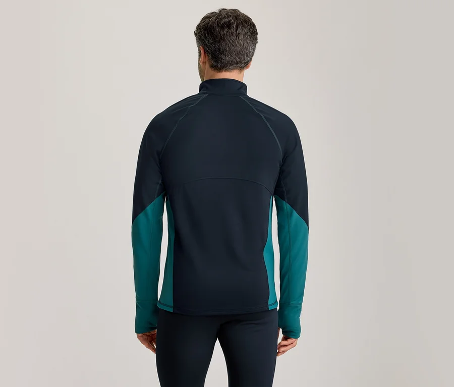 Homme de dos portant un haut de sport à manches longues bleu foncé et sarcelle, et un pantalon bleu foncé.
