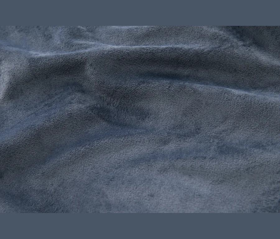 Gros plan d'un tissu bleu doux et texturé avec des plis et des froissements visibles.