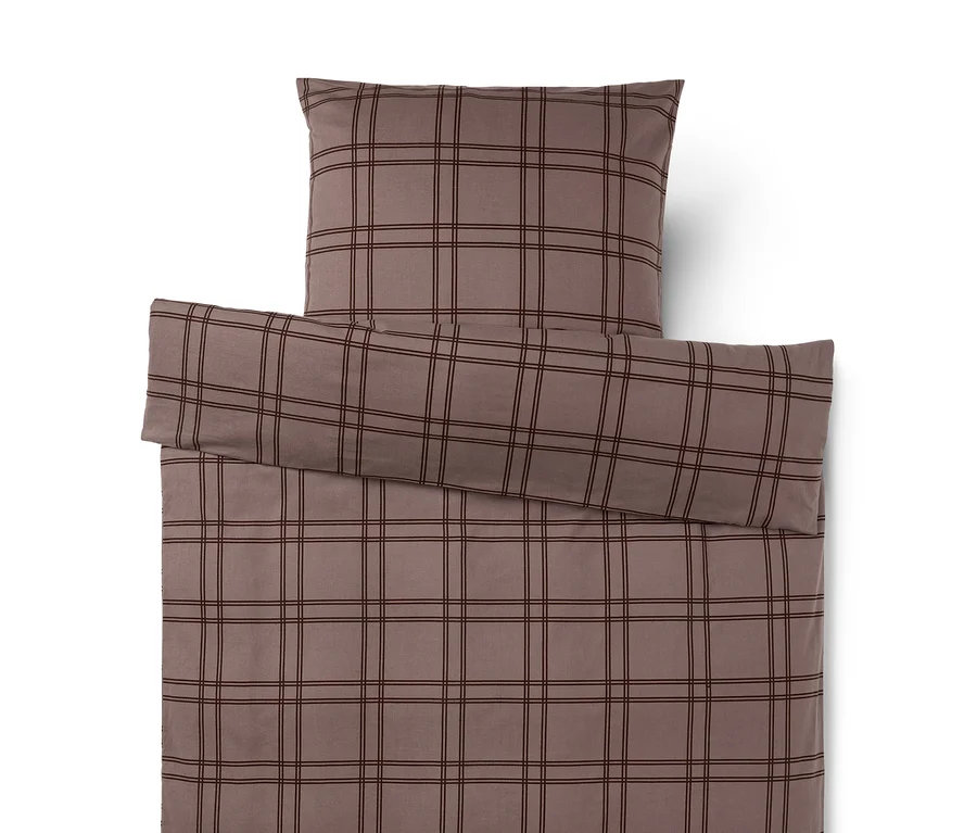 Housse de couette et taie d'oreiller marron à carreaux marron foncé. La taie d'oreiller est posée sur la housse de couette.