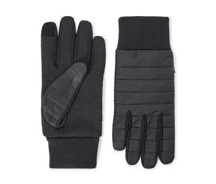 Une paire de gants noirs. Le gant gauche montre une paume à pois antidérapants et un pouce matelassé. Le gant droit montre un dos matelassé. Les deux ont des poignets côtelés.