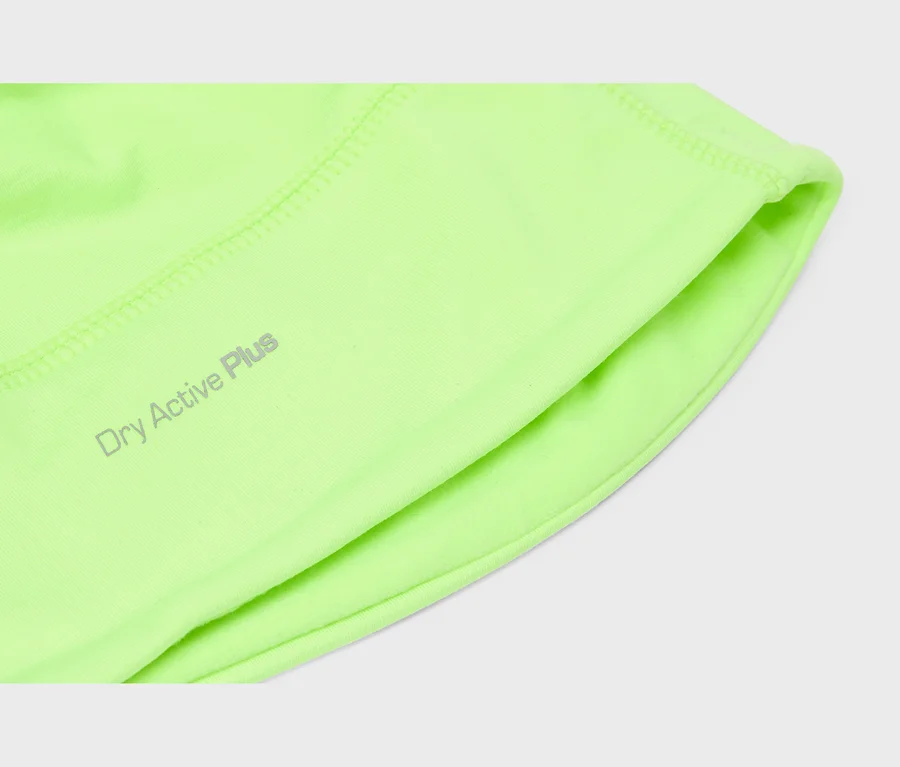 Gros plan sur un tissu de vêtement de sport vert néon avec l'inscription grise 'Dry Active Plus', montrant des coutures visibles et un bord plié.