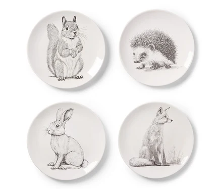 Quatre assiettes à dessert décorées, chacune avec un motif animalier: un écureuil, un hérisson, un lapin et un renard.