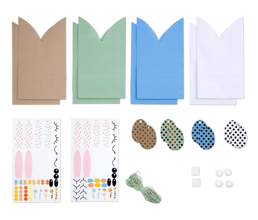 Un kit de fabrication de pochettes cadeau en forme de lapin comprenant des pochettes marron, vertes, bleues et blanches, des autocollants, des étiquettes en forme d'œufs et de la ficelle.