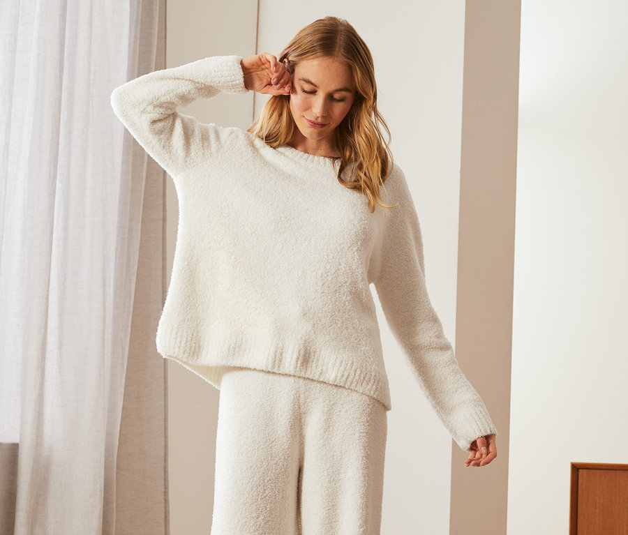 Femme posant dans un sweat-shirt moelleux et un pantalon.