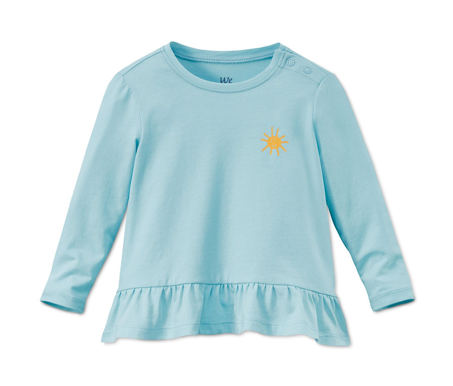 Un t-shirt à manches longues bleu clair en coton bio avec un soleil jaune. Le t-shirt a un ourlet à volants.