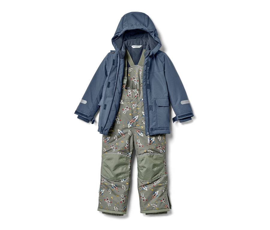 Combinaison de ski pour enfant avec veste bleue et pantalon gris à motifs de fusées et d'astronautes.