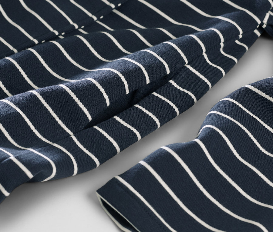 Gros plan sur une robe de chambre bleu marine rayée blanc.