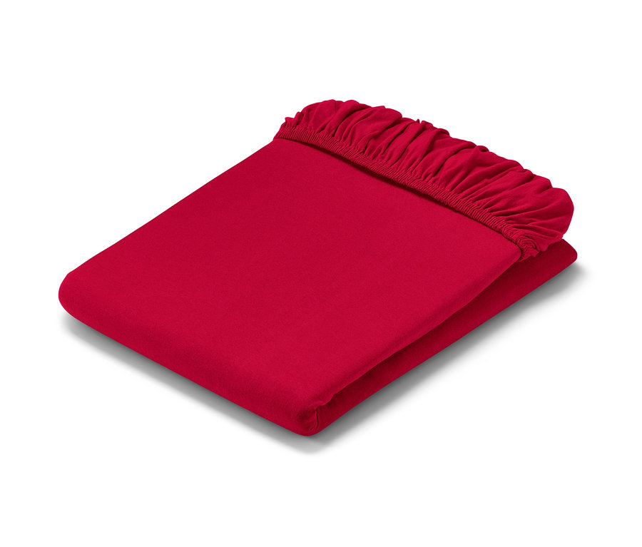 Un drap-housse en jersey rouge plié.