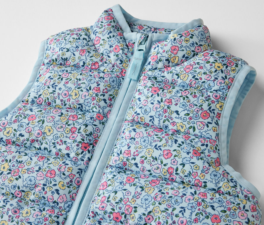 Détail d'un gilet sans manches matelassé pour enfant, à fleurs.
