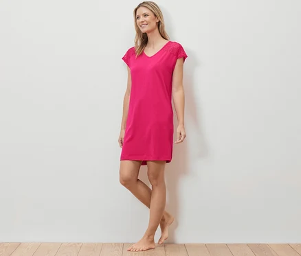 Femme debout portant une chemise de nuit rose.