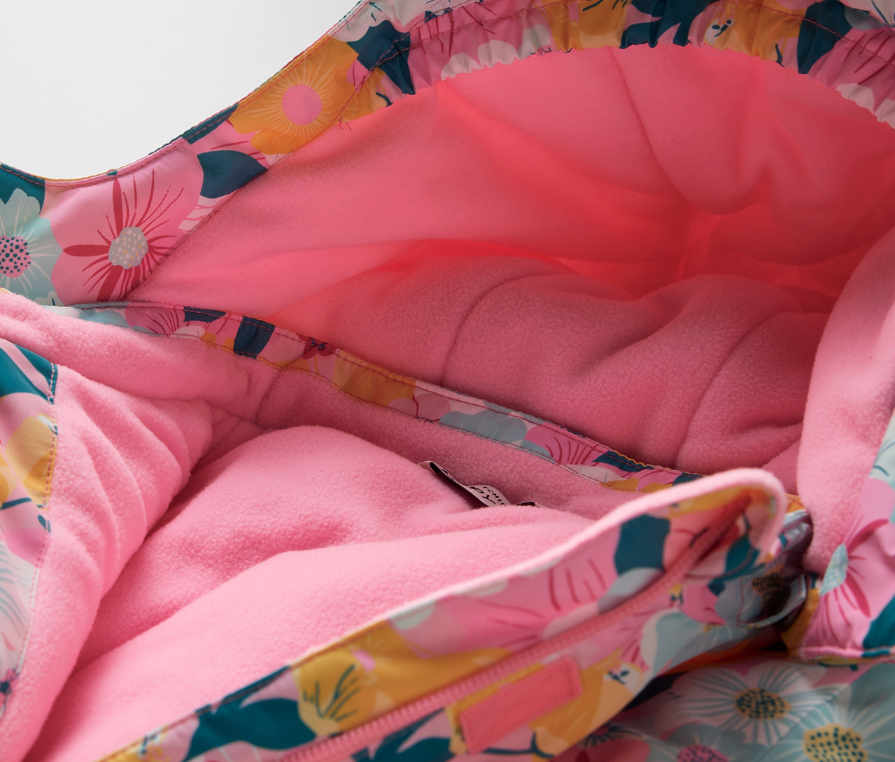 Gros plan de la capuche d'une veste à motif floral avec une doublure rose.