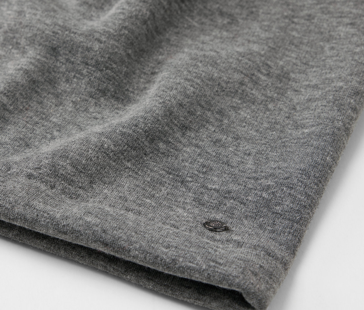 Gros plan d'un tissu gris avec un petit logo.