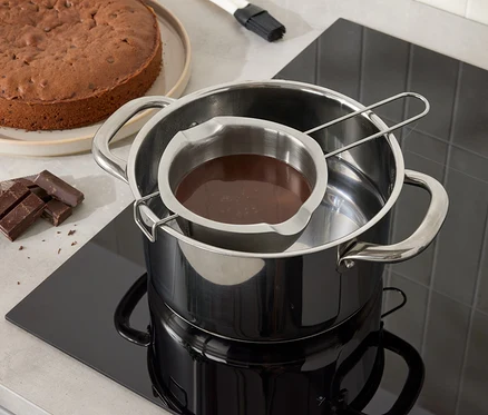 Gâteau au chocolat et chocolat fondant dans un bol en inox sur une casserole d'eau.