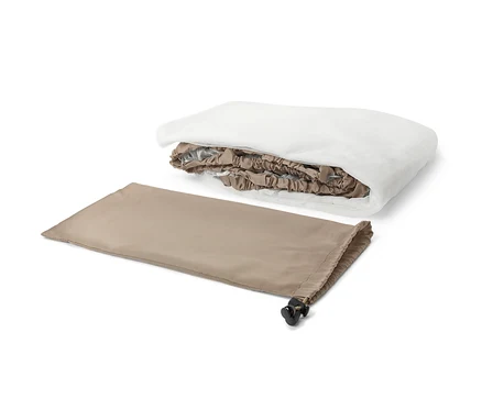 Une moustiquaire de voyage pliée et son sac beige.