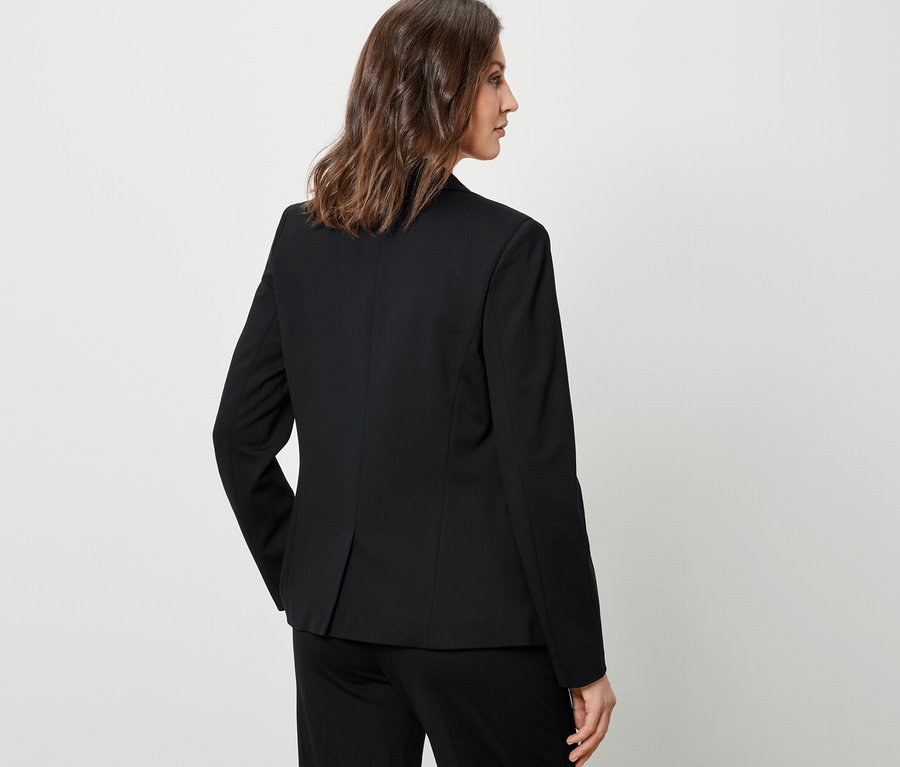 Femme portant un blazer en jersey noir.