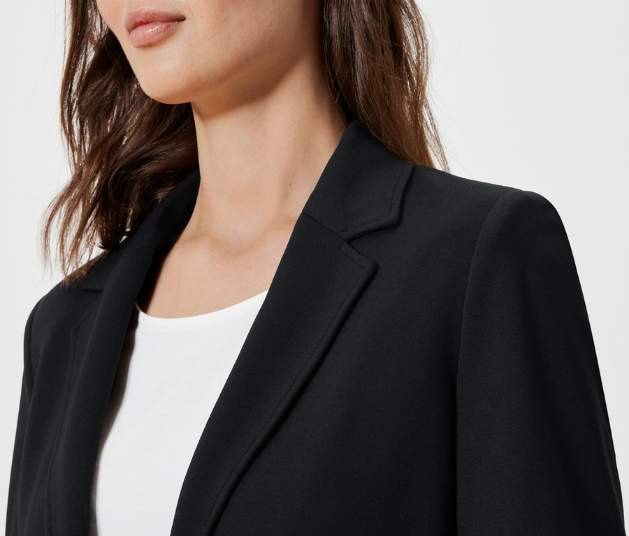 Gros plan d'une femme portant un blazer en jersey noir.
