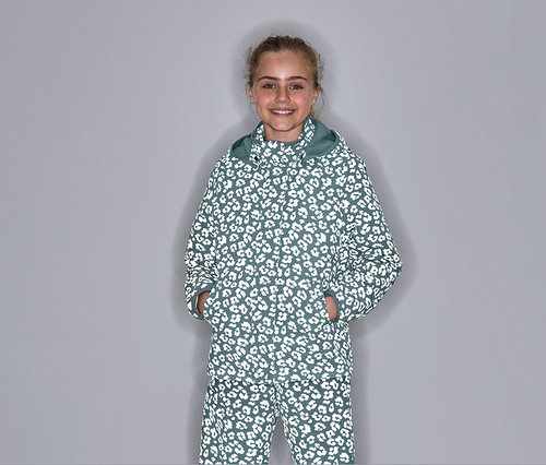 Une fille pose dans une veste de pluie thermique avec des éléments réfléchissants et un motif léopard.