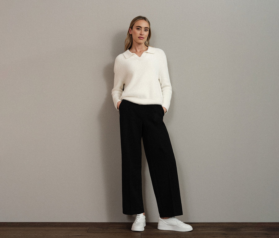 Femme portant un pull en maille à col polo Street One blanc, un pantalon noir et des chaussures blanches.