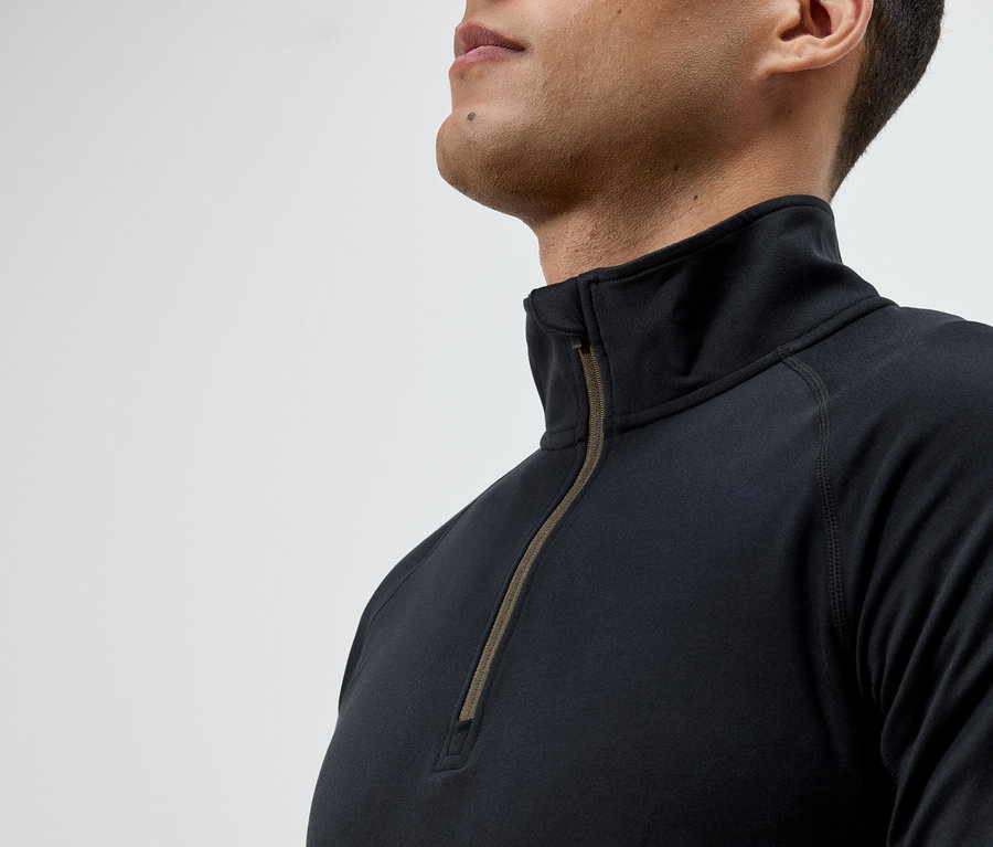 Un homme porte un t-shirt noir à manches longues avec une fermeture éclair.