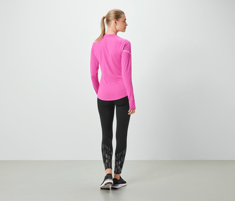Une femme, vue de dos, porte un haut rose à manches longues et un legging noir.