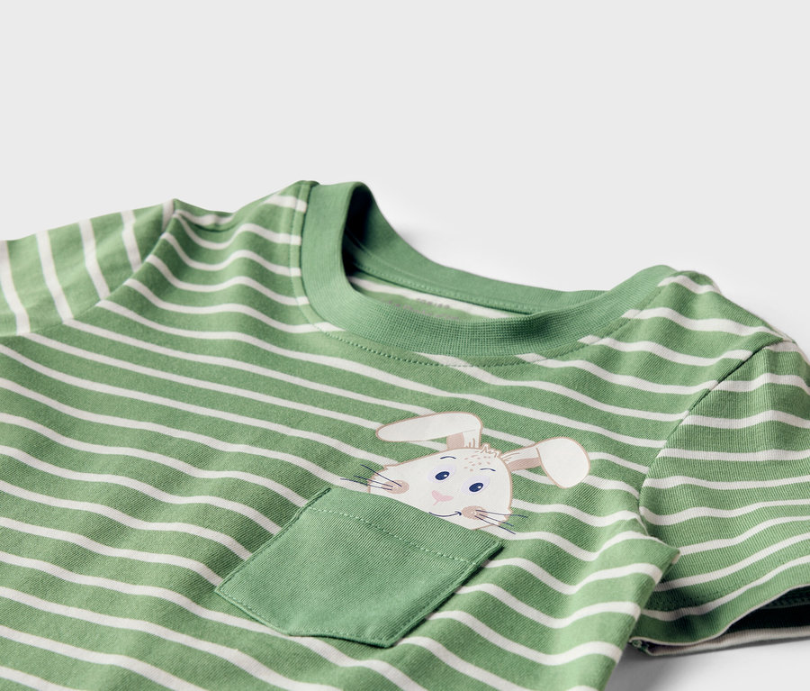 T-shirt vert et blanc rayé avec un motif de lapin sur la poche de poitrine.