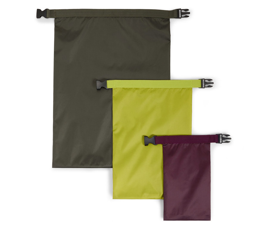 Trois sacs étanches de différentes tailles et couleurs (olive, citron vert, violet) sont posés sur un fond blanc.