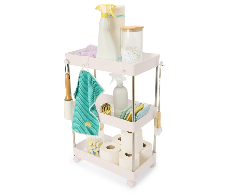 Produits de nettoyage et accessoires rangés sur un chariot à trois niveaux.
