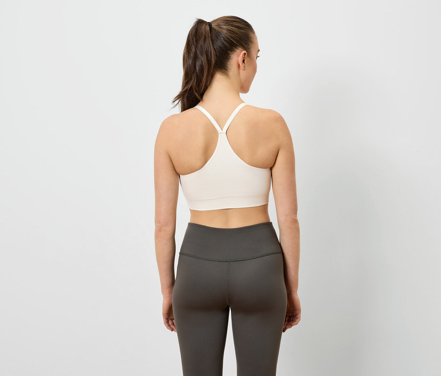 Femme vue de dos portant un soutien-gorge de sport et un legging.