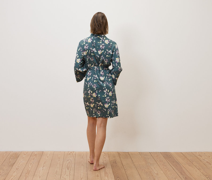 Femme vue de dos portant un peignoir fleuri.