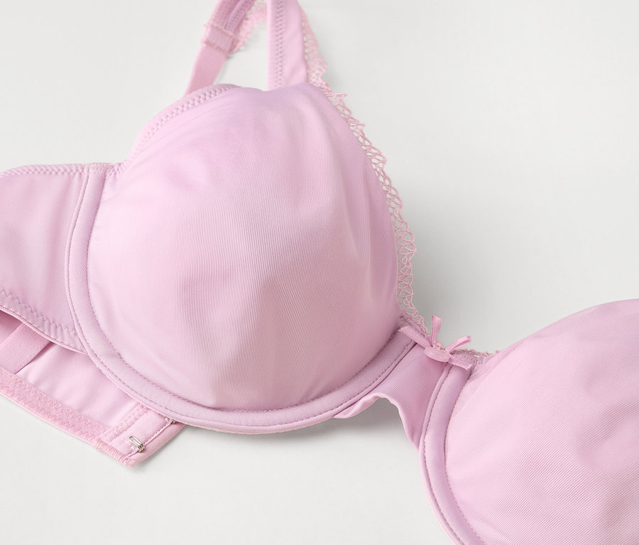 Gros plan d'un soutien-gorge à armatures rose clair avec de la dentelle.