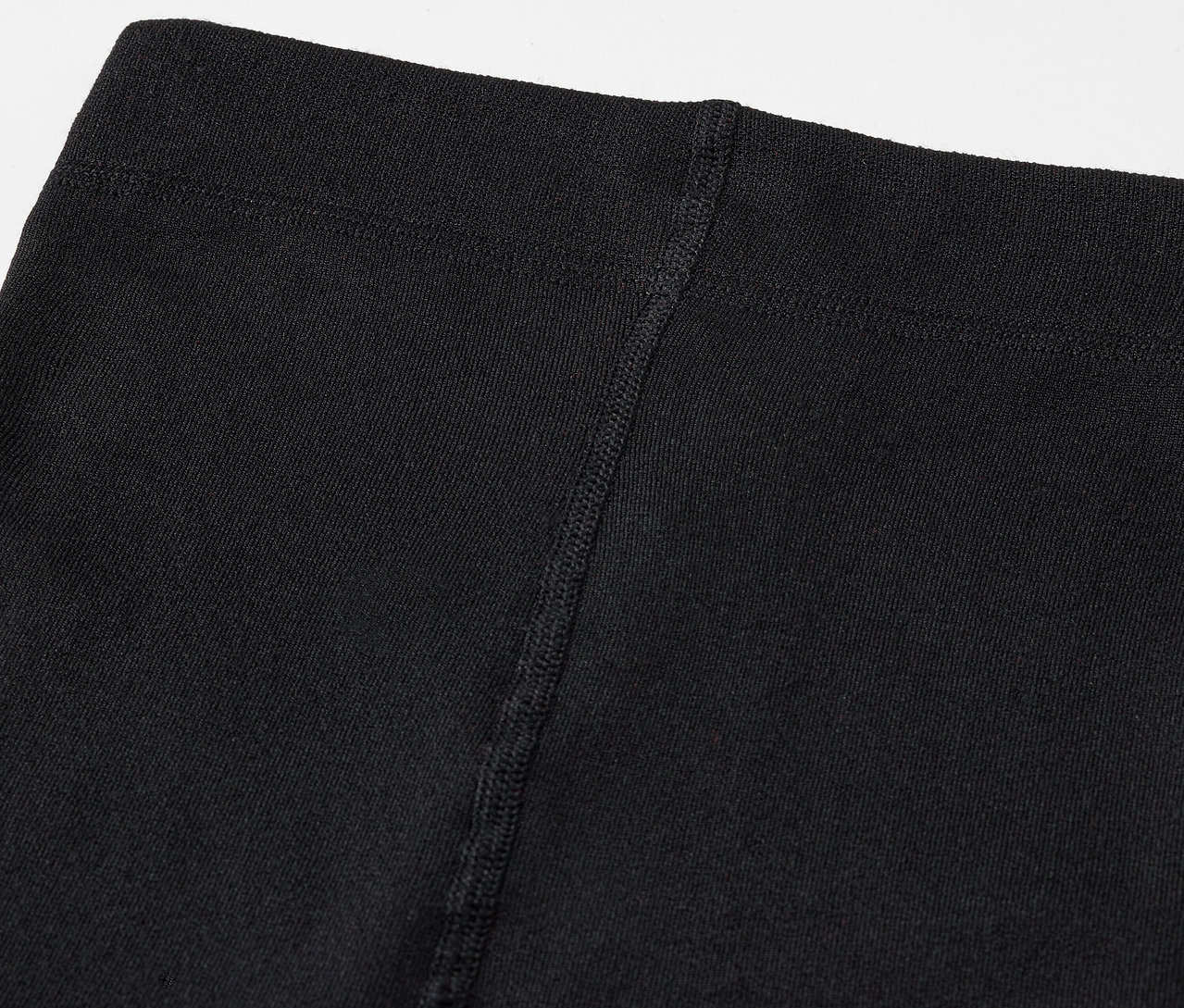 Gros plan sur le haut d'un legging noir avec une couture visible.