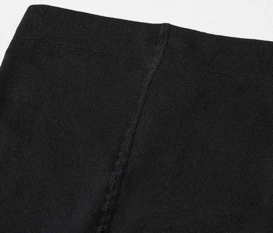 Gros plan sur le haut d'un legging noir avec une couture visible.