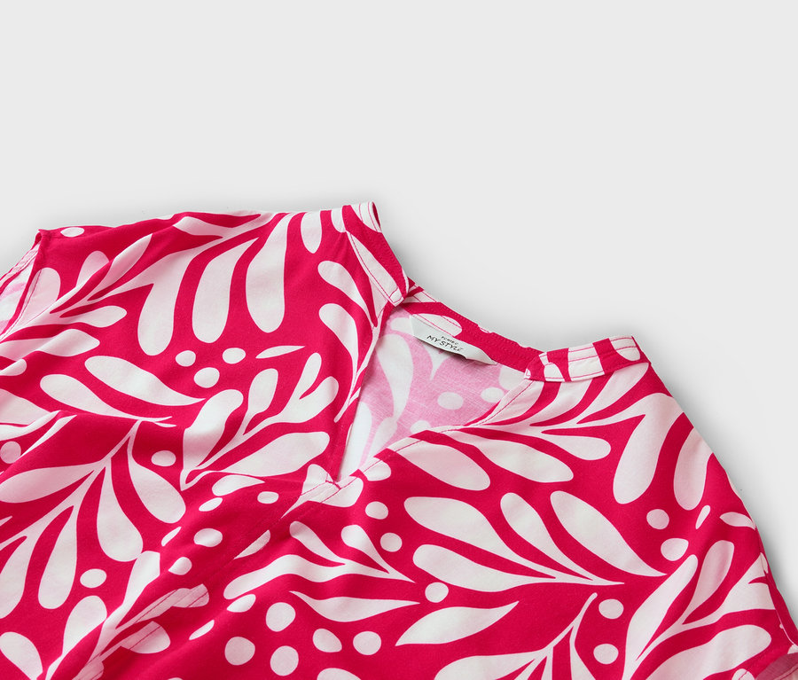 Gros plan d'une robe rouge et blanche à motif de feuilles avec un col en V.