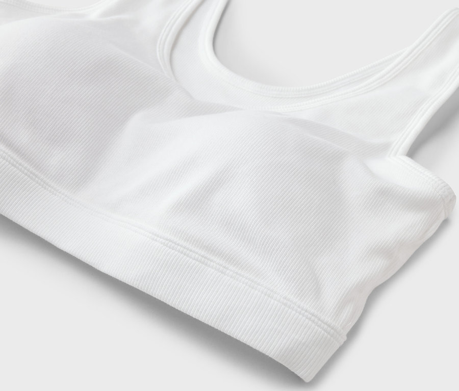 Gros plan d'un soutien-gorge de sport blanc côtelé sur fond blanc.